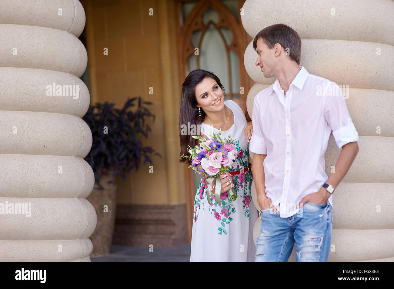 happy bride and groom walking among the columns Stock Photo