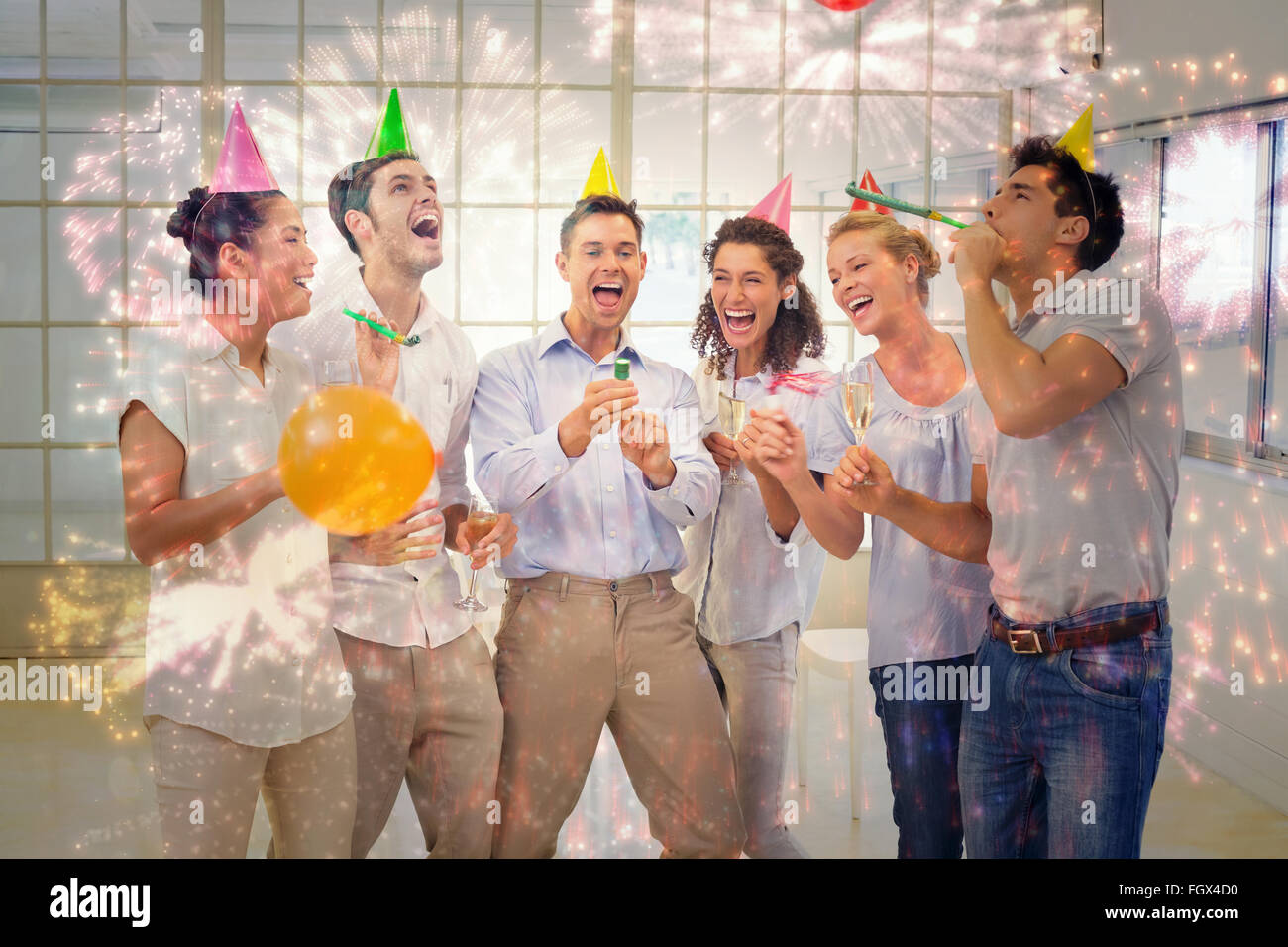 Composite image of casual business team celebrating with champagne and party poppers Stock Photo