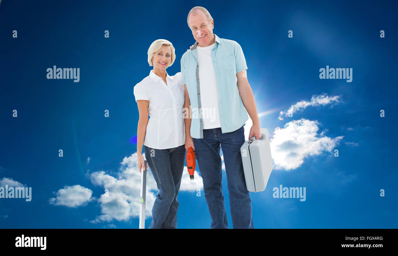 Composite image of happy older couple holding diy tools Stock Photo