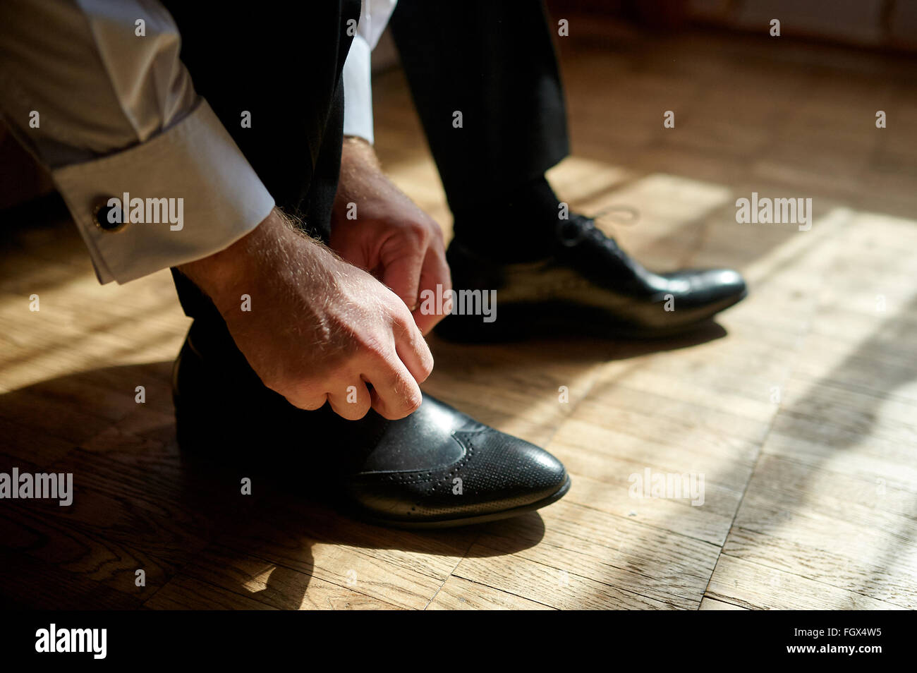 Business man tying shoe laces on the floor Stock Photo