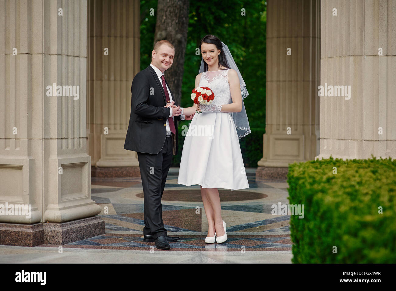 bride and groom with a bouquet of walking in the summer park Stock Photo