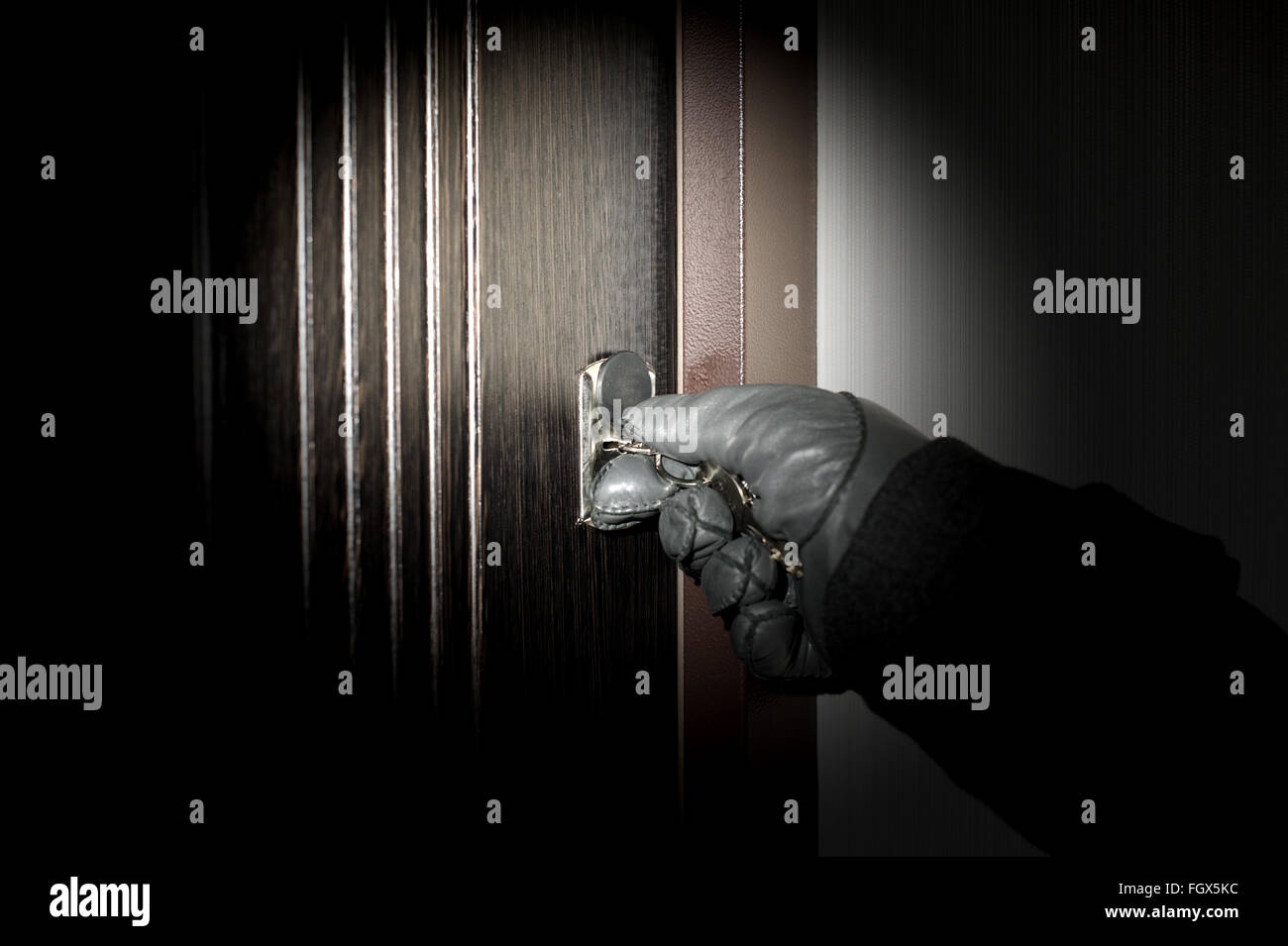 Villain opens the apartment burglary at night Stock Photo