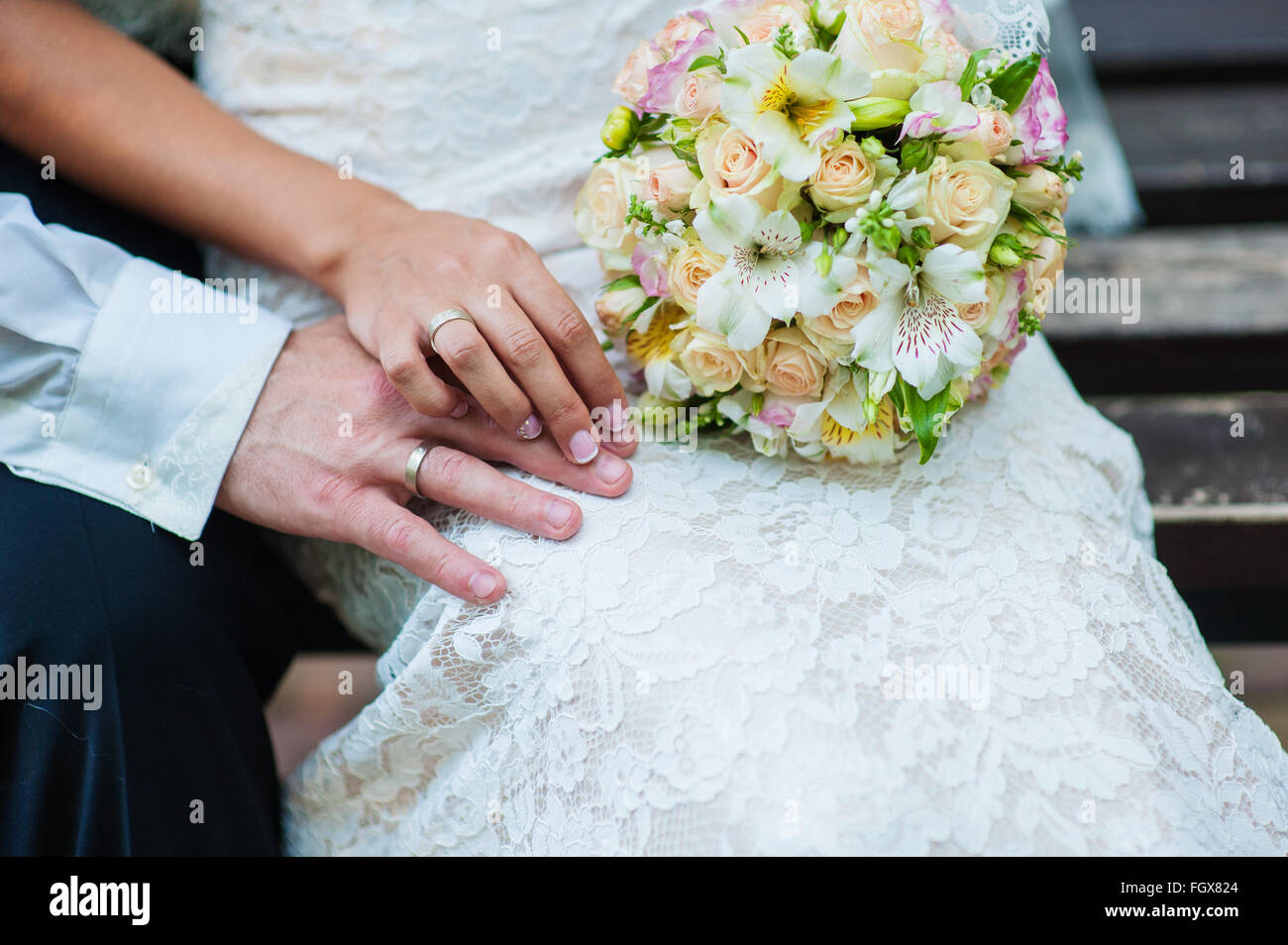 hands of bride and groom with rings on wedding bouquet Stock Photo - Alamy