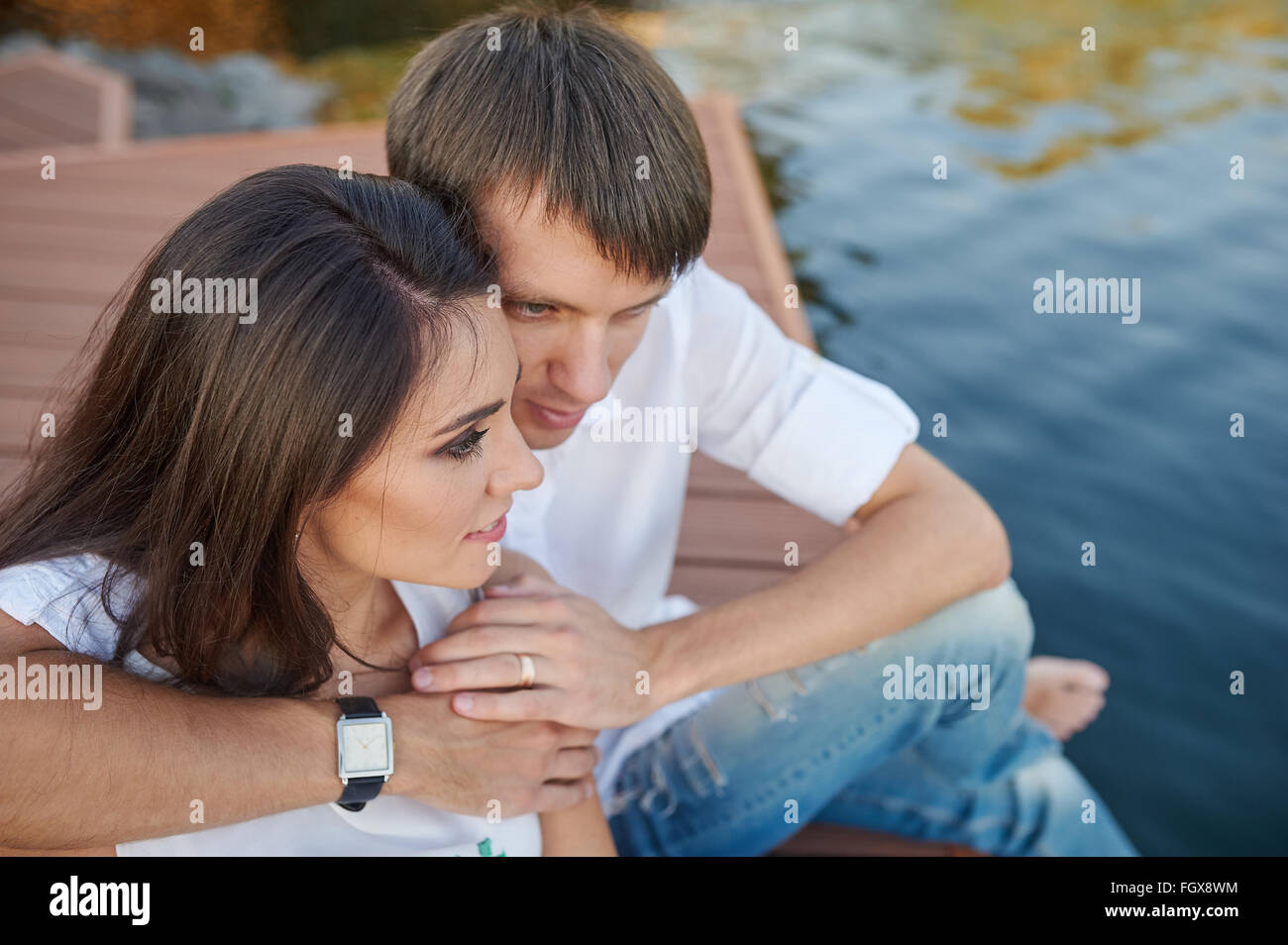 couple embracing on a wooden pier near the river Stock Photo - Alamy