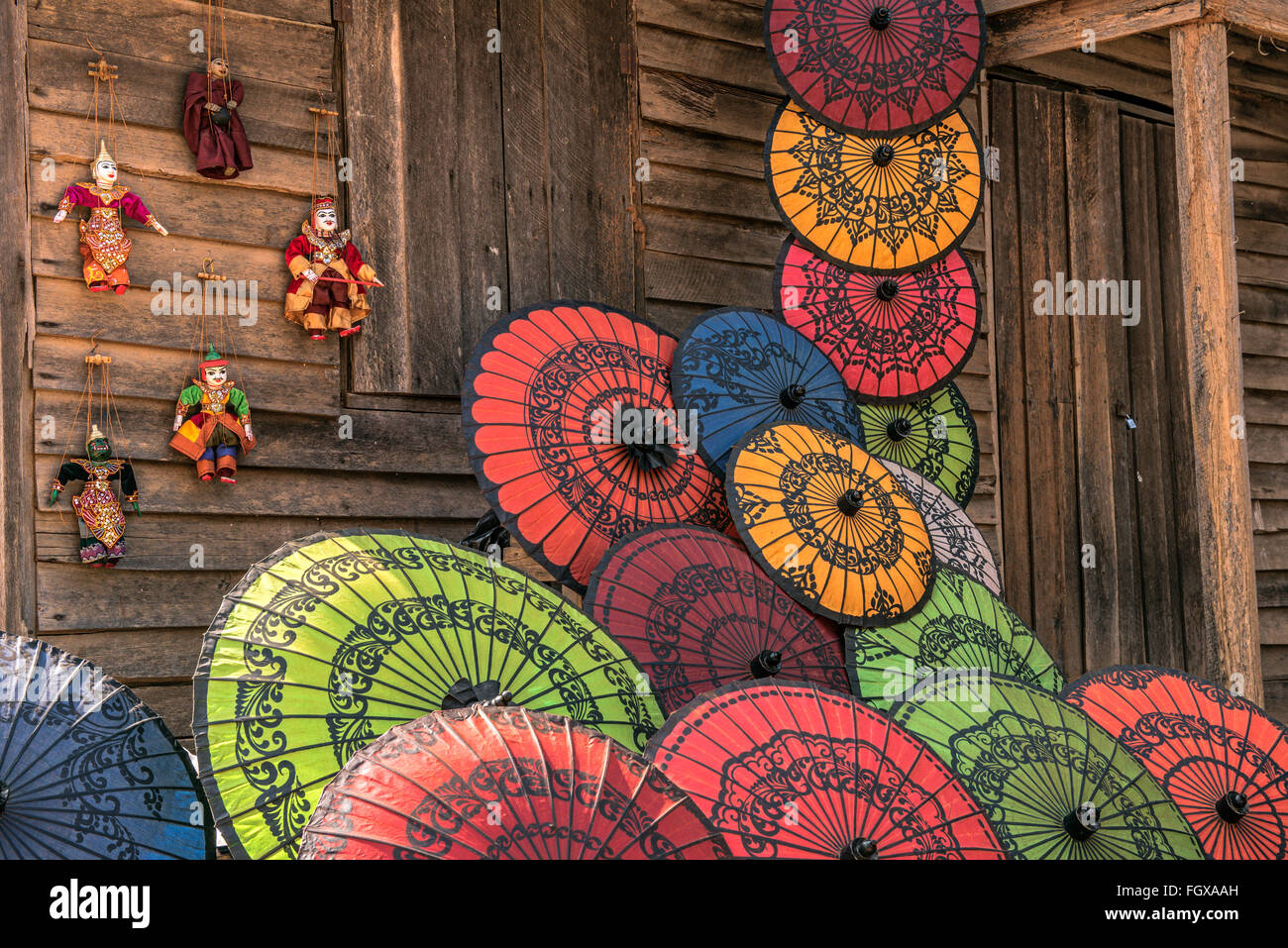 Colorful paper umbrellas arranged on a wooden wall  for sale as souvernirs in Asia Stock Photo
