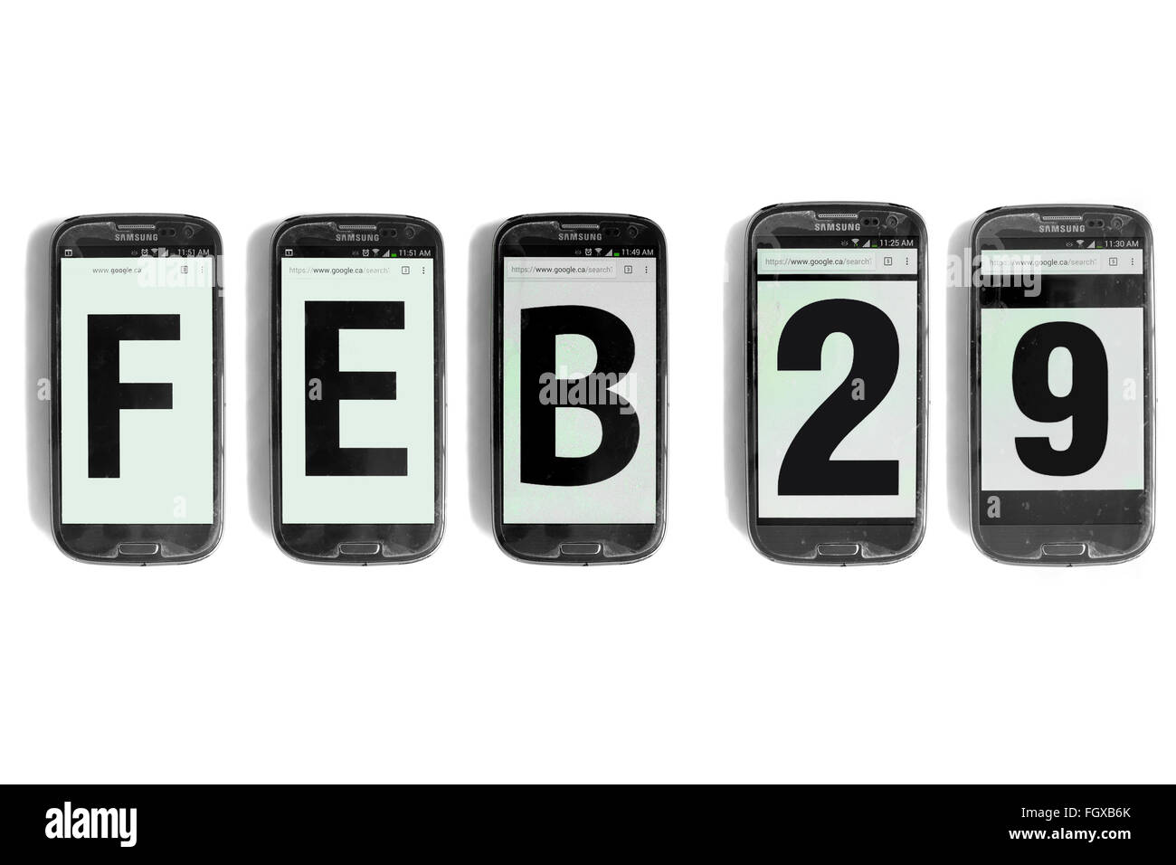 Feb 29 written on the screens of smartphones photographed against a white background. Stock Photo