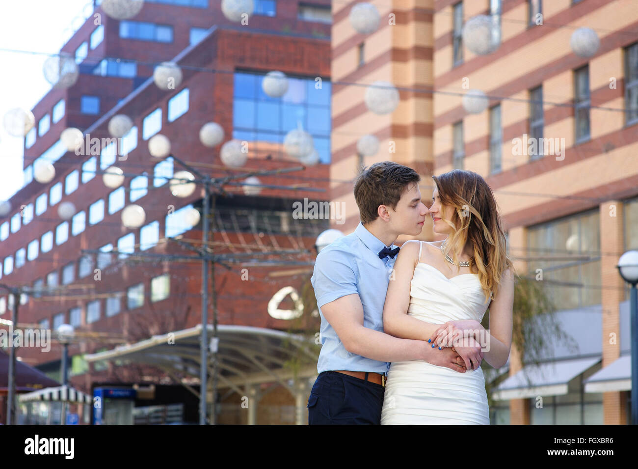 Bride and groom walking around among the houses buildings Stock Photo