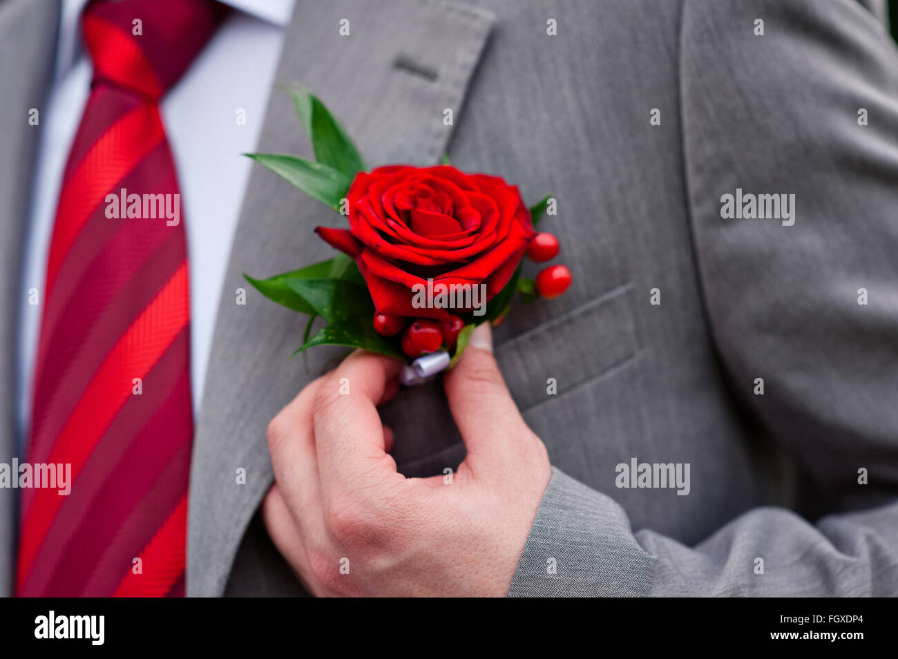 groom in red tie with rose on his jacket Stock Photo