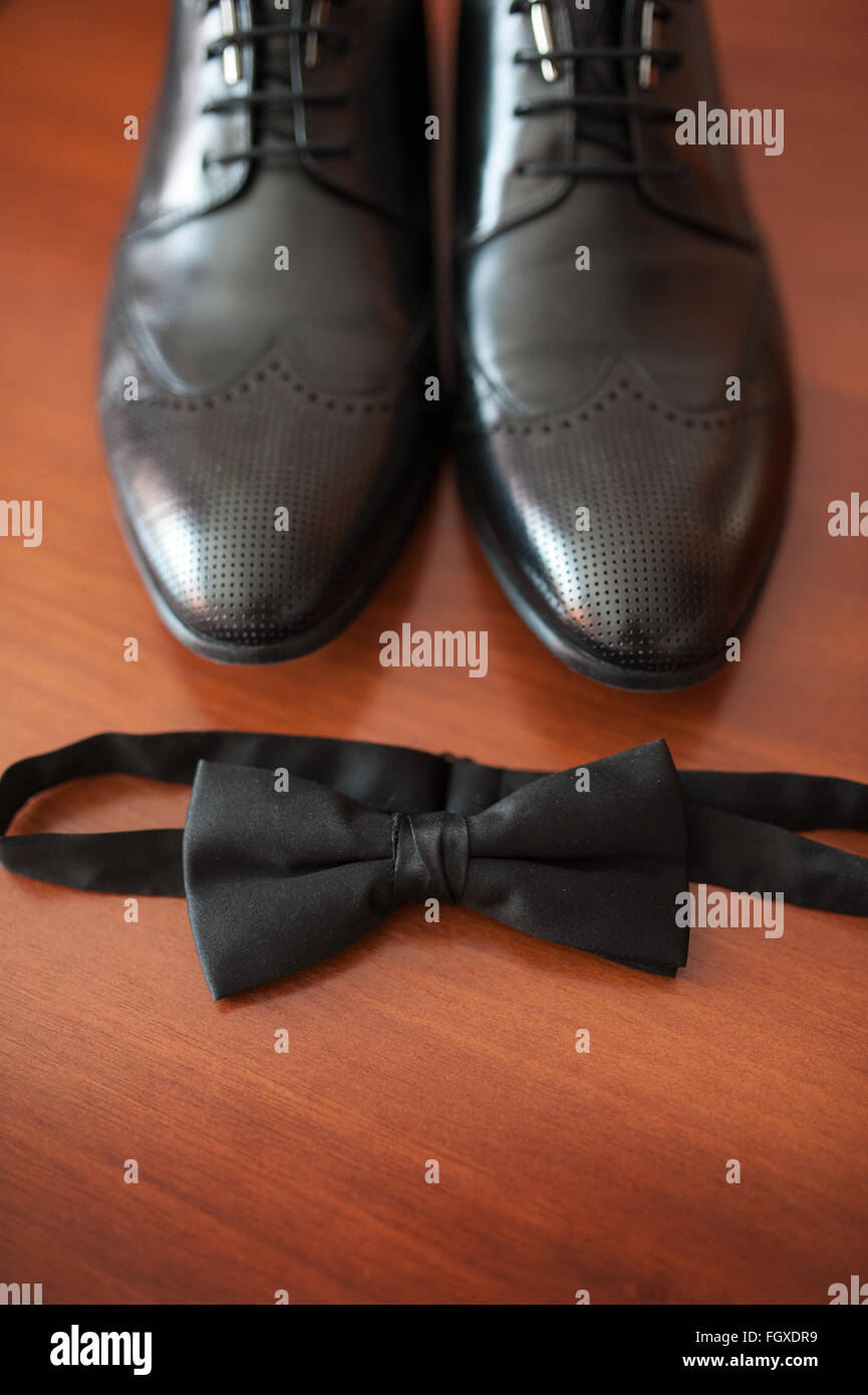 close-up of lightened with natural light men's shoes and bow tie Stock Photo