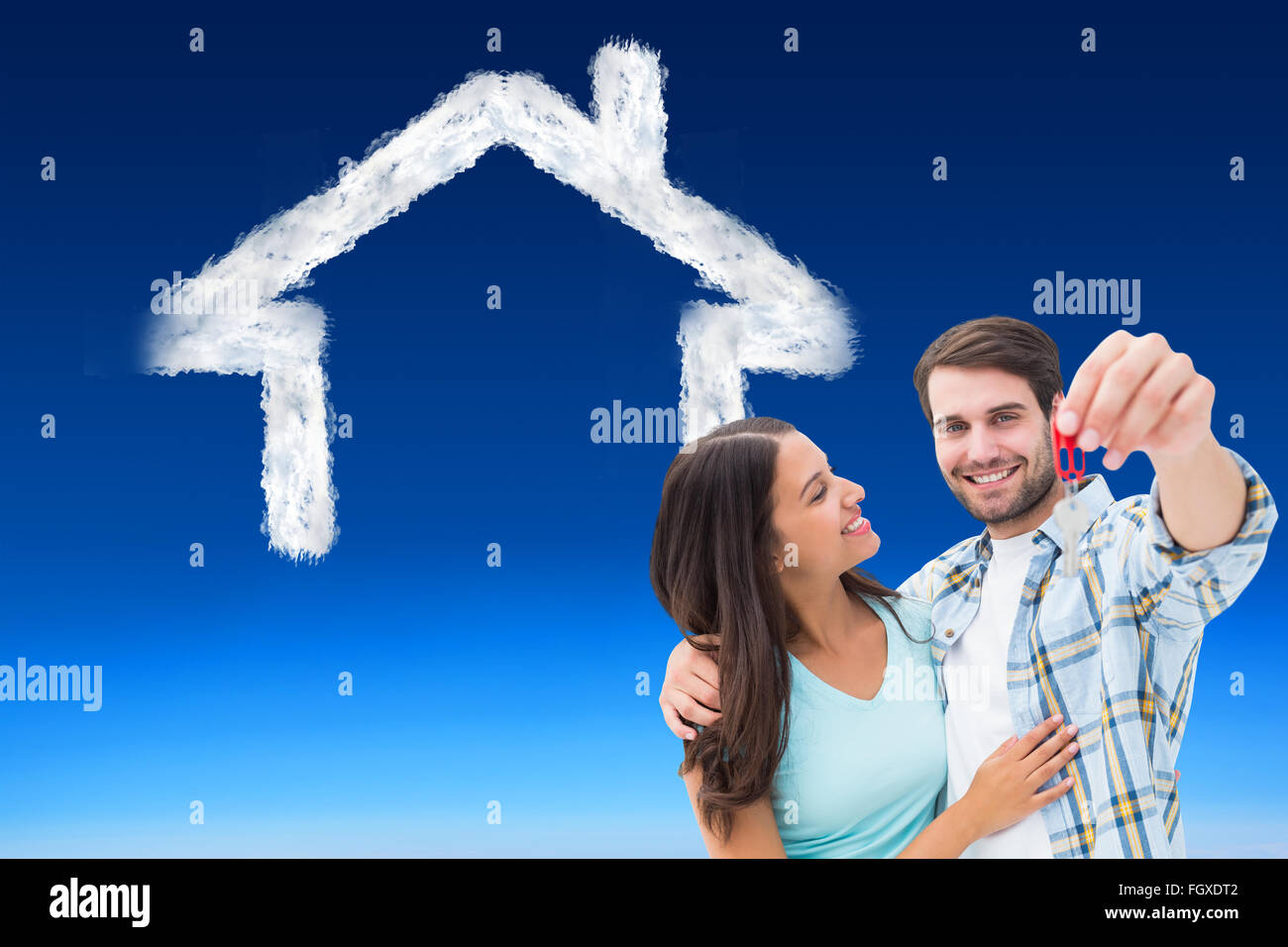 Composite image of happy young couple showing new house key Stock Photo ...