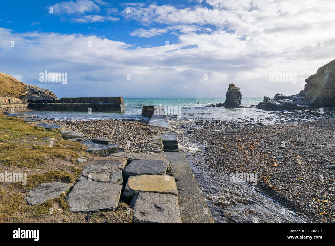 LATHERONWHEEL HARBOUR CAITHNESS SCOTLAND THE LATHERONWHEEL RIVER RUNNING ALONGSIDE THE HARBOUR WALL TO ENTER THE SEA Stock Photo