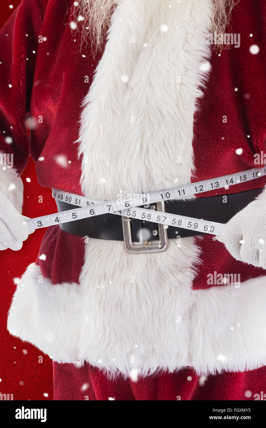 Composite image of santa claus measures his belly Stock Photo