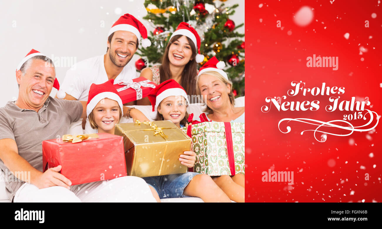 Composite image of happy family at christmas holding gifts Stock Photo