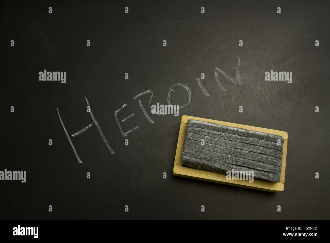 Heroin written in white chalk on blackboard with eraser. Stock Photo