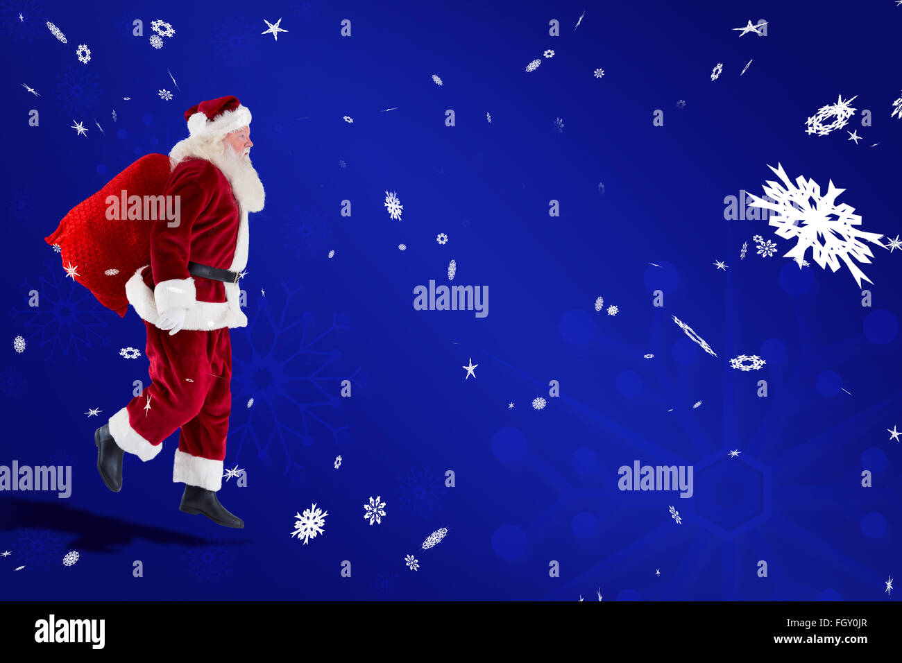 Composite image of santa claus carrying sack Stock Photo - Alamy