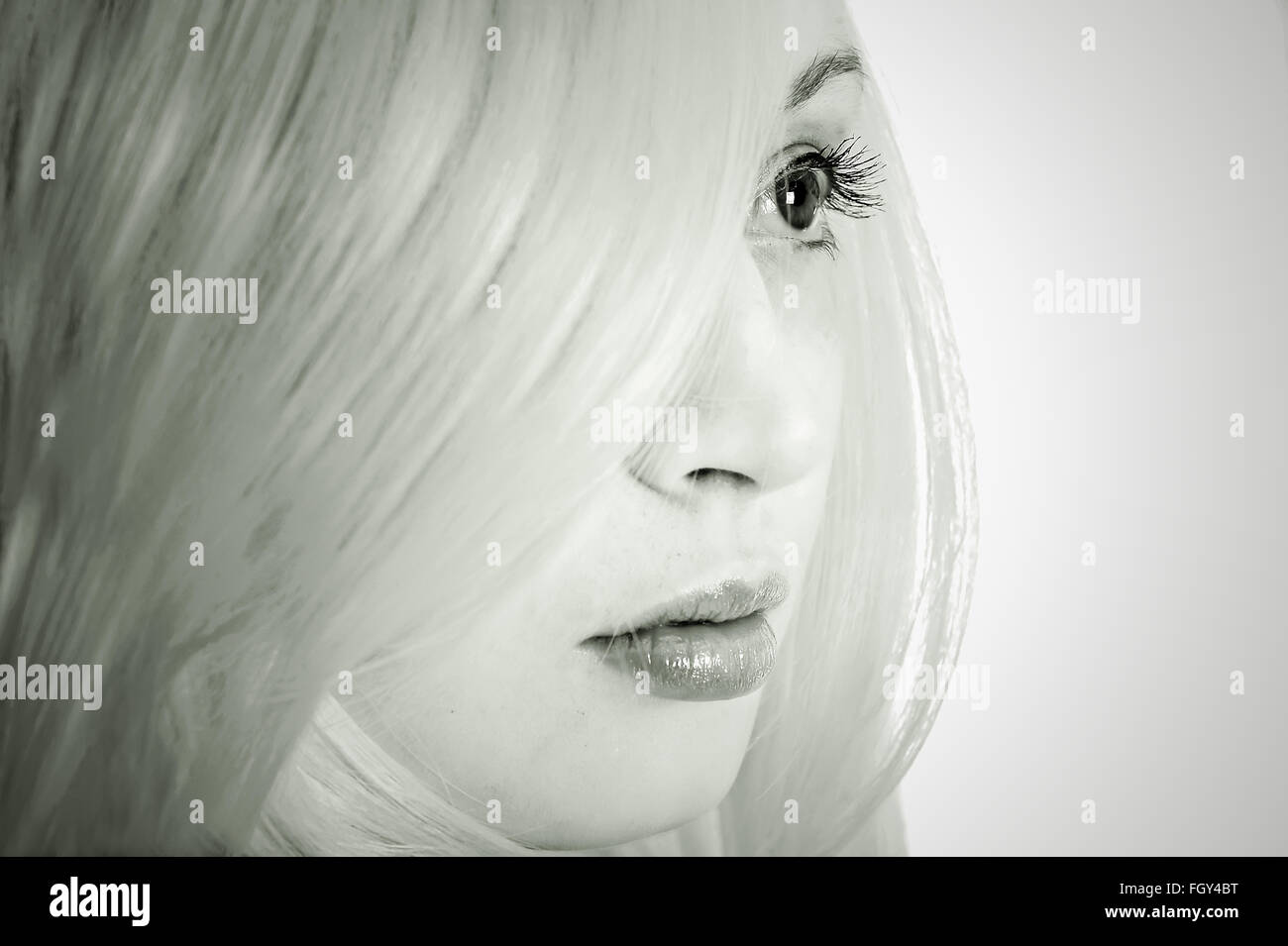 Black and white image of close up portrait of girl behind her white hair Stock Photo