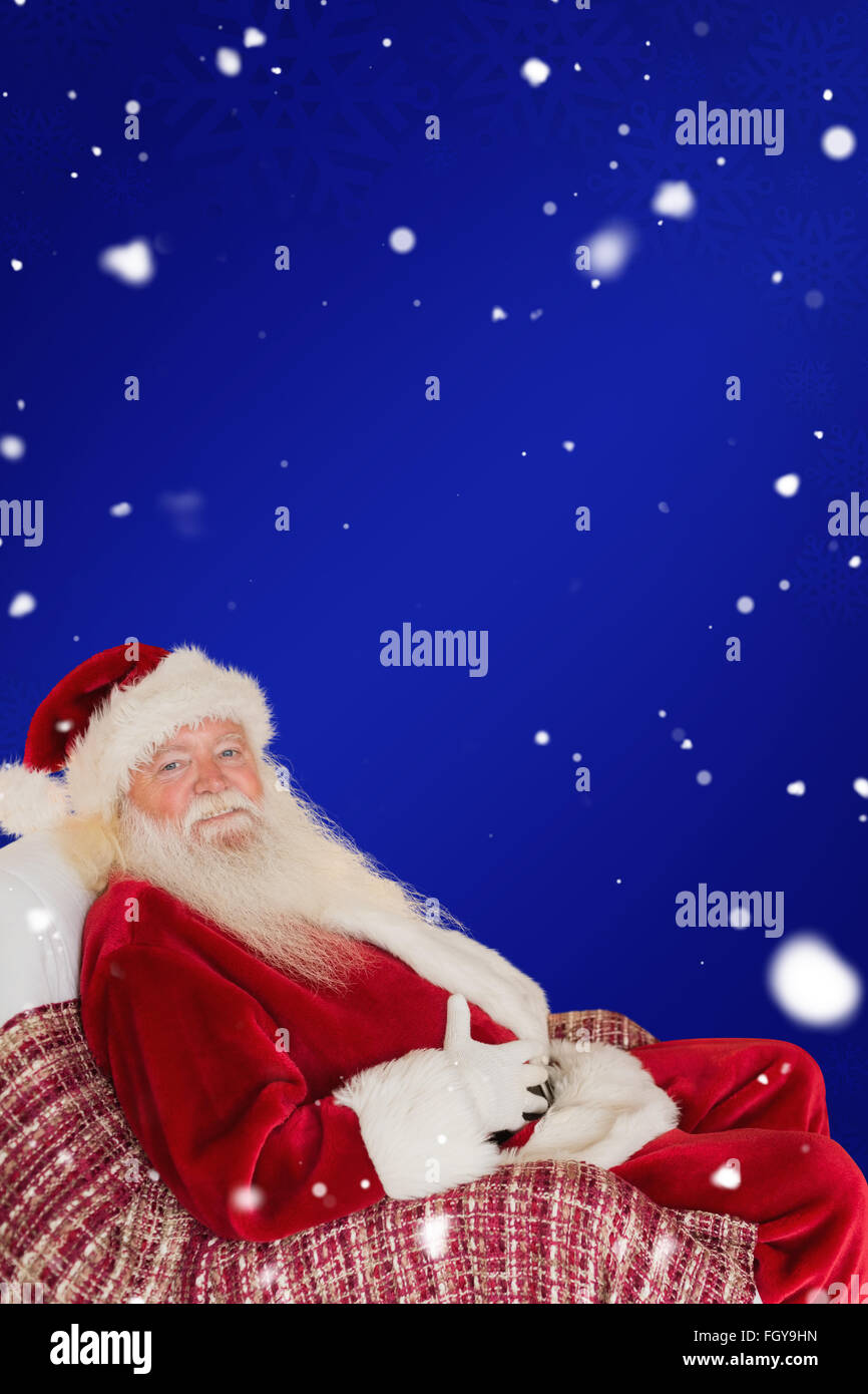 Composite image of santa holding his belly on the armchair Stock Photo ...