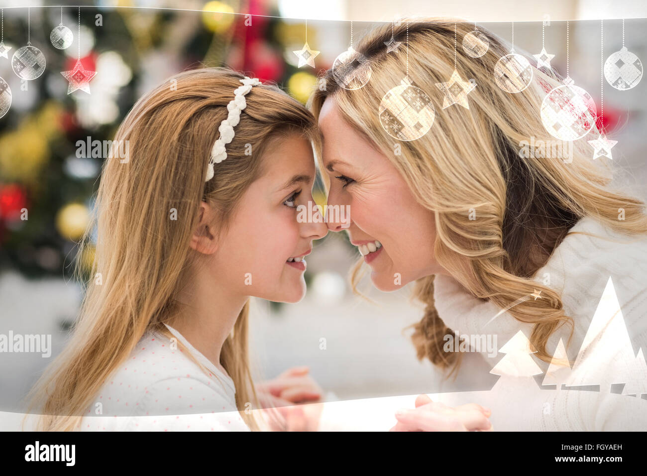 Composite image of festive mother and daughter beside christmas tree Stock Photo