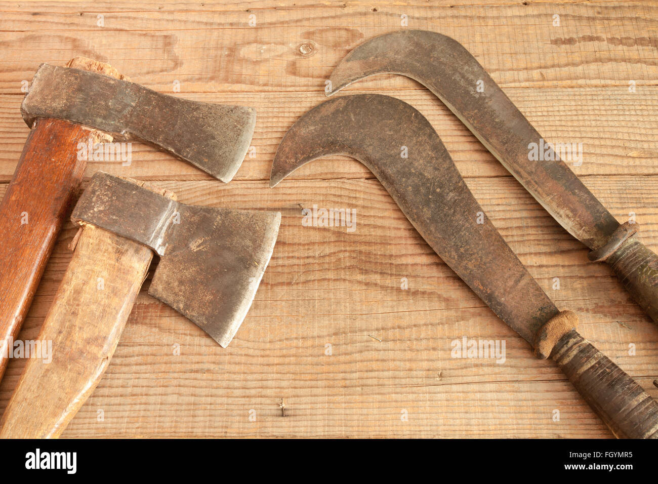 Two dated and used cleavers and billhooks on wooden background Stock Photo