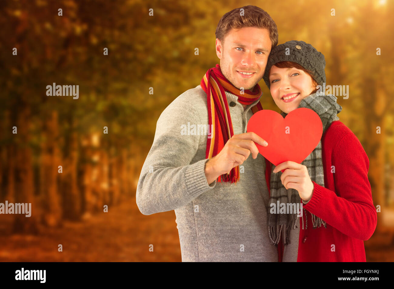 Composite image of couple holding a red heart Stock Photo - Alamy