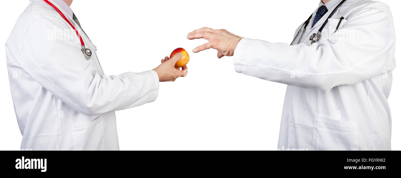One doctor passing an apple to another doctor wearing stethoscopes isolated on a pure white background Stock Photo