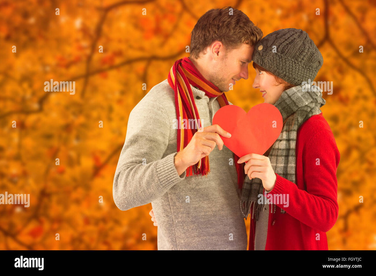 Composite image of couple holding a red heart Stock Photo - Alamy