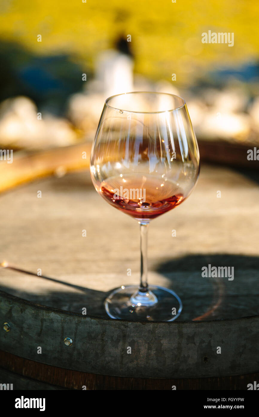 A glass of rosé sits on an old wine barrel in Santa Ynez, California. Stock Photo