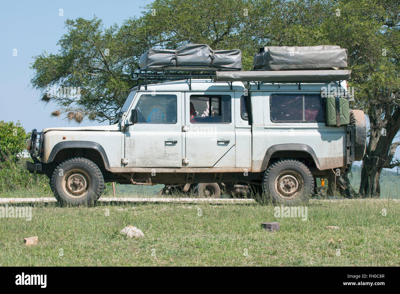 Old Land Rover Defender 110  with two roof tents Parked at roadside refreshment van Tanzania Stock Photo