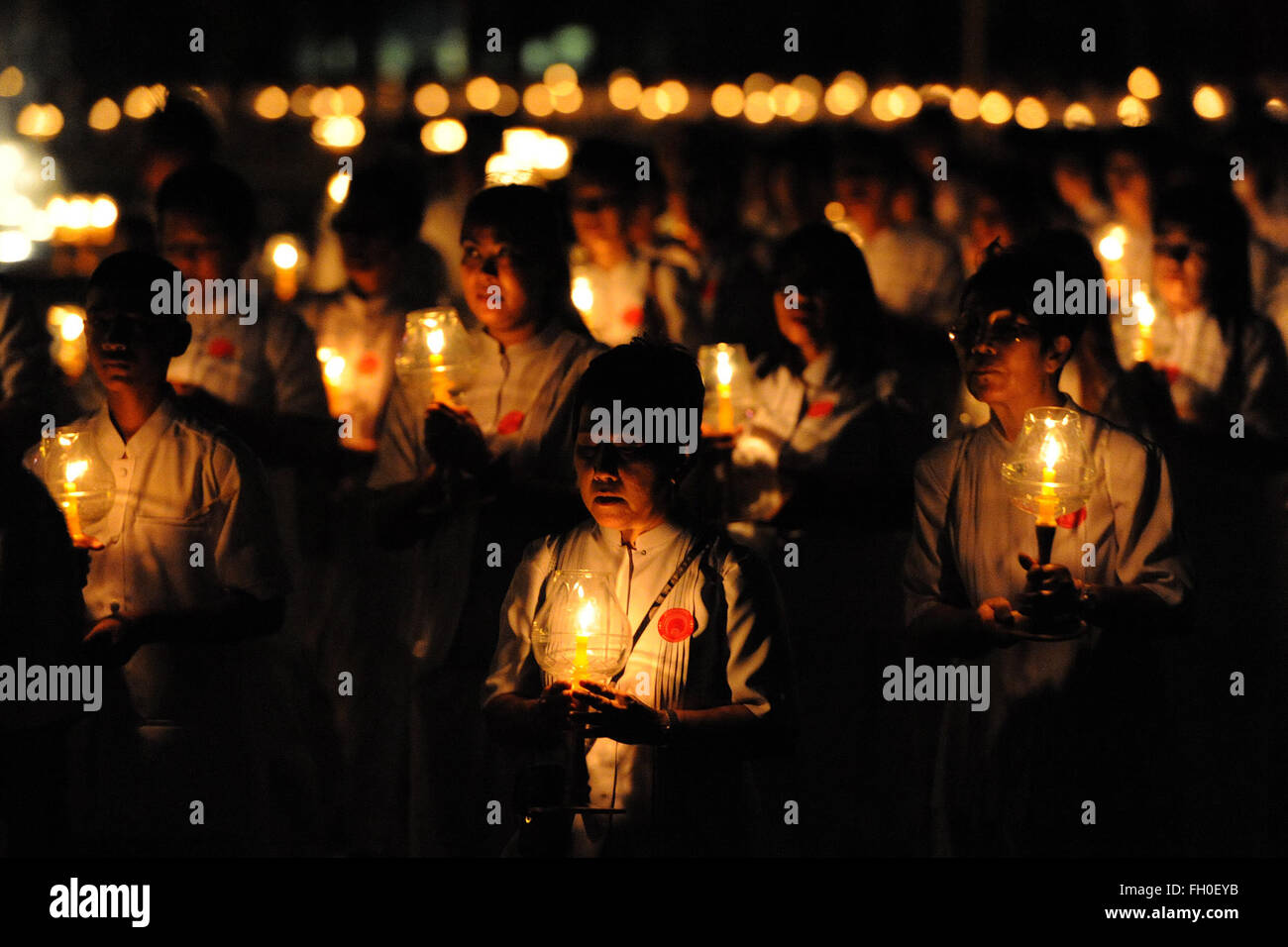 Pathum Thani, Thailand. 22nd Feb, 2016. Thai people light candles and pray during Makha Bucha Day ceremonies at Wat Phra Dhammakaya Temple in Pathum Thani Province, Thailand, on Feb. 22, 2016. As one of Thailand's most important Buddhist festivals, Makha Bucha is observed every full moon night of the third month in the Thai lunar calendar. On the Makha Bucha day, people flock to temples and venerate Buddhas as well as pray for blessedness. Credit:  Rachen Sageamsak/Xinhua/Alamy Live News Stock Photo