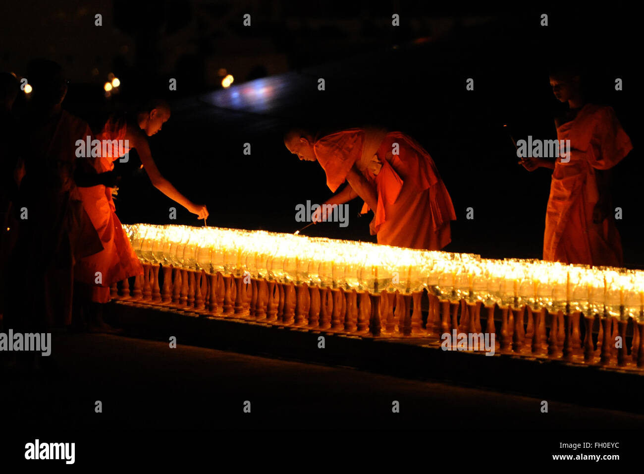 Pathum Thani, Thailand. 22nd Feb, 2016. Thai Buddhist monks light candles during Makha Bucha Day ceremonies at Wat Phra Dhammakaya Temple in Pathum Thani Province, Thailand, on Feb. 22, 2016. As one of Thailand's most important Buddhist festivals, Makha Bucha is observed every full moon night of the third month in the Thai lunar calendar. On the Makha Bucha day, people flock to temples and venerate Buddhas as well as pray for blessedness. Credit:  Rachen Sageamsak/Xinhua/Alamy Live News Stock Photo