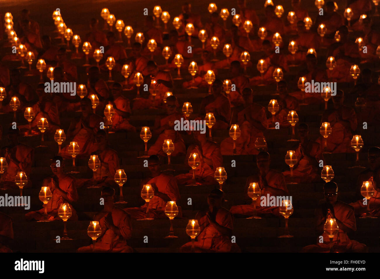 Pathum Thani, Thailand. 22nd Feb, 2016. Thai Buddhist monks light candles and pray during Makha Bucha Day ceremonies at Wat Phra Dhammakaya Temple in Pathum Thani Province, Thailand, on Feb. 22, 2016. As one of Thailand's most important Buddhist festivals, Makha Bucha is observed every full moon night of the third month in the Thai lunar calendar. On the Makha Bucha day, people flock to temples and venerate Buddhas as well as pray for blessedness. Credit:  Rachen Sageamsak/Xinhua/Alamy Live News Stock Photo