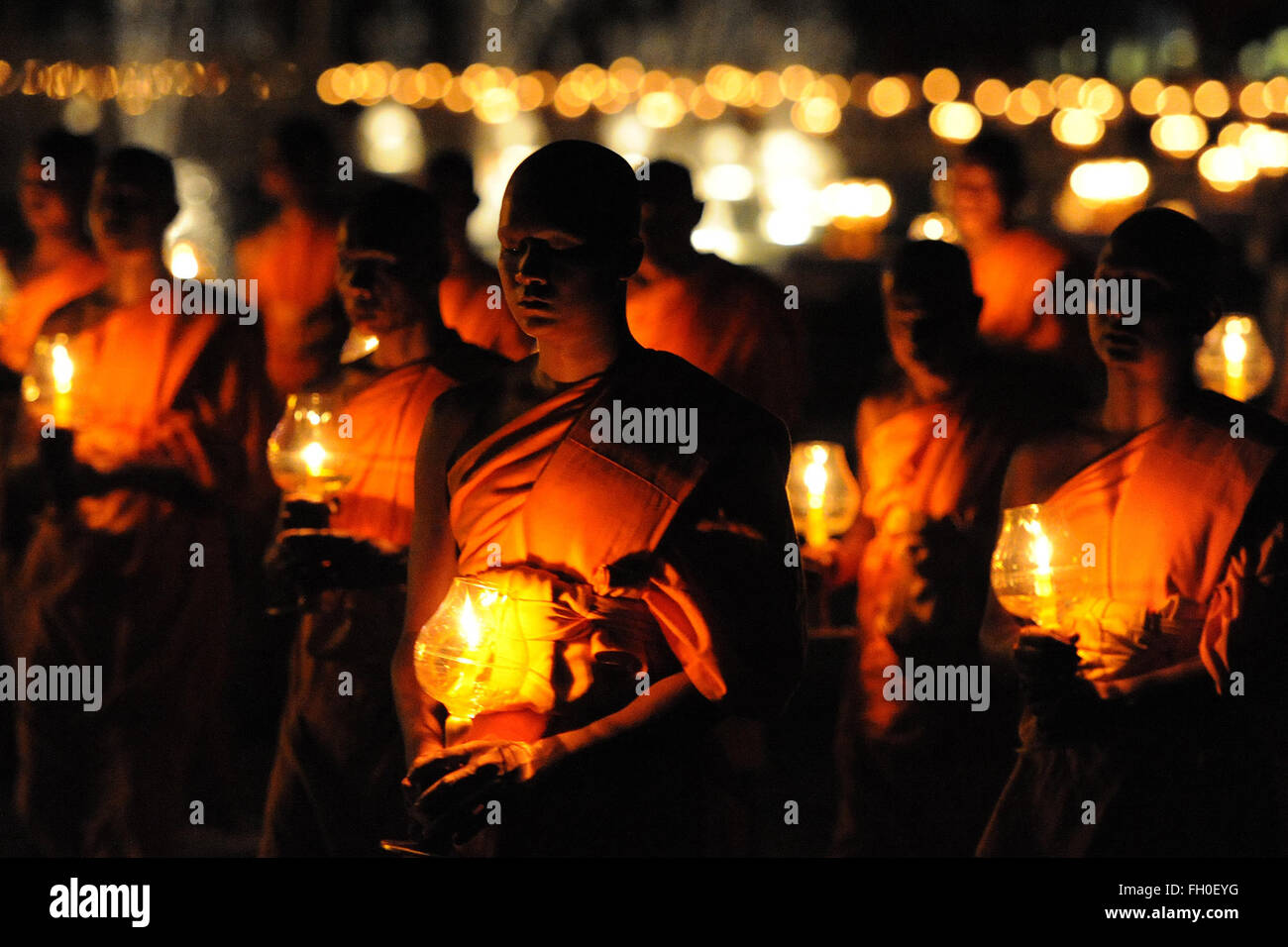 Pathum Thani, Thailand. 22nd Feb, 2016. Thai Buddhist monks light candles and pray during Makha Bucha Day ceremonies at Wat Phra Dhammakaya Temple in Pathum Thani Province, Thailand, on Feb. 22, 2016. As one of Thailand's most important Buddhist festivals, Makha Bucha is observed every full moon night of the third month in the Thai lunar calendar. On the Makha Bucha day, people flock to temples and venerate Buddhas as well as pray for blessedness. Credit:  Rachen Sageamsak/Xinhua/Alamy Live News Stock Photo