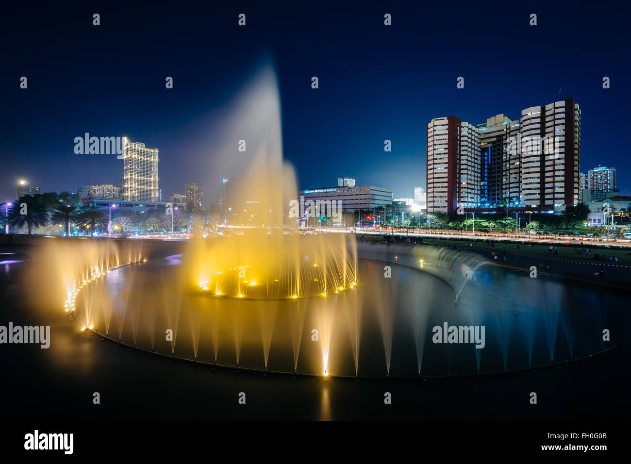 Fountain and modern buildings at night, in Pasay, Metro Manila, The Philippines. Stock Photo