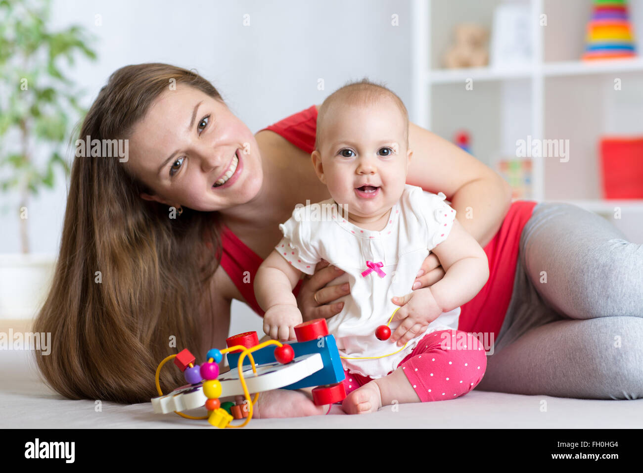Baby with mom. Mother and daughter indoor. Little girl and woman play