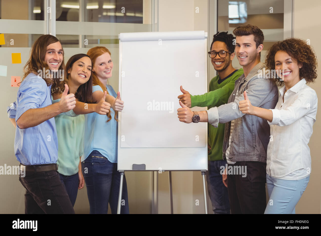 Smiling business people showing thumbs up Stock Photo - Alamy