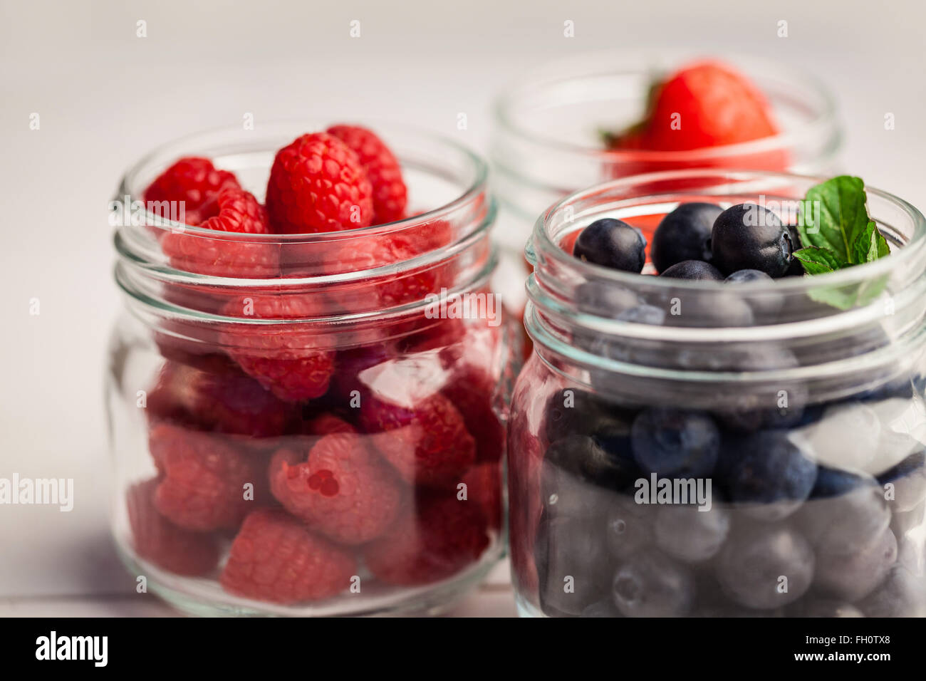 Glass jars of fresh berries Stock Photo