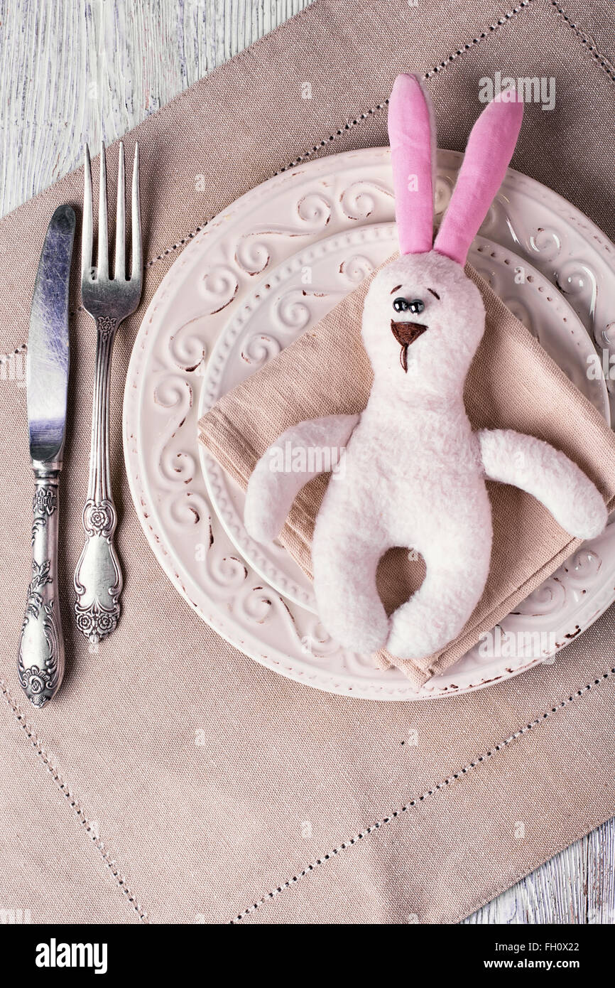 Plate,knife and fork with a toy rabbit for Easter dinner Stock Photo