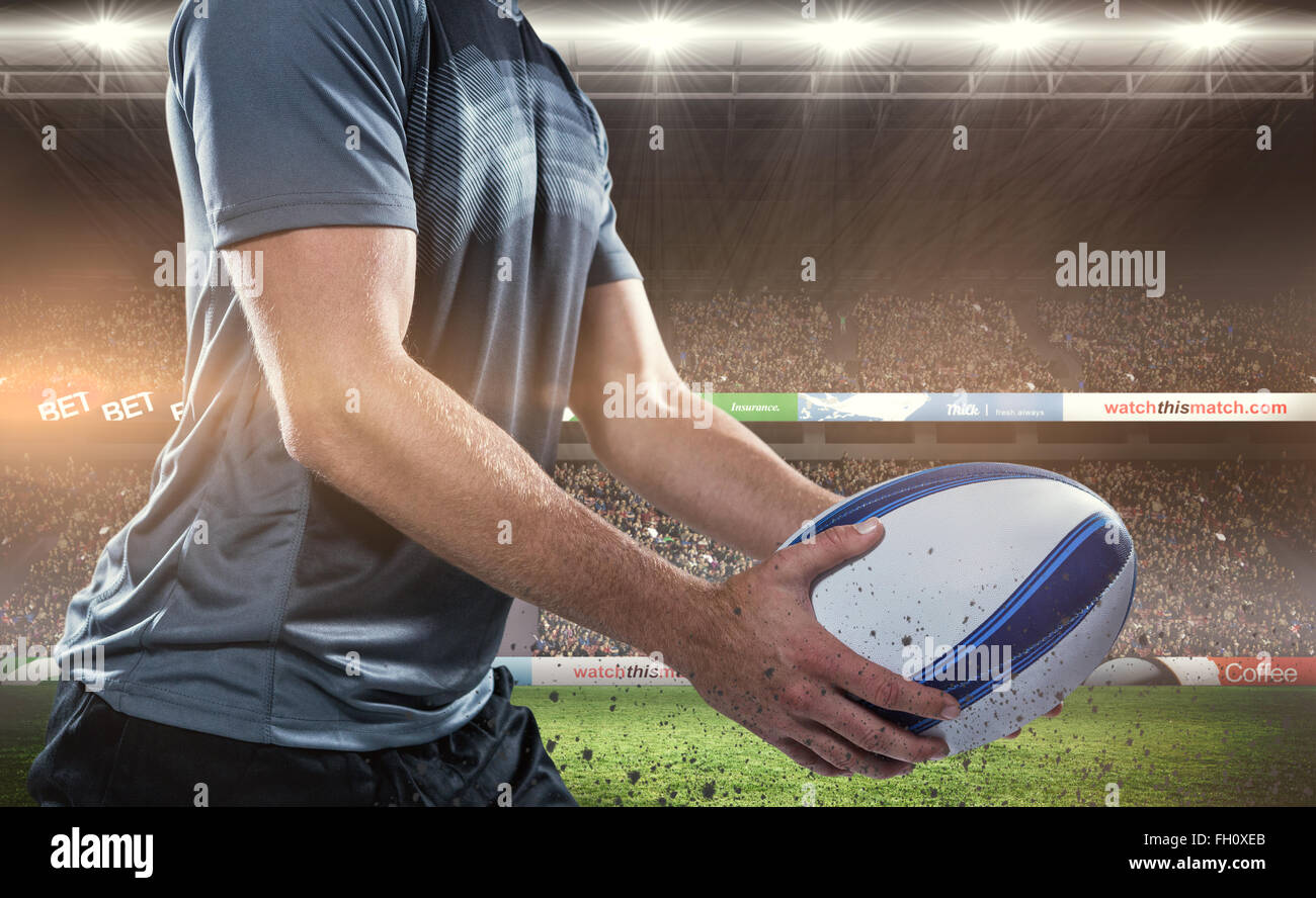 Composite image of midsection of rugby player in black jersey holding ball Stock Photo
