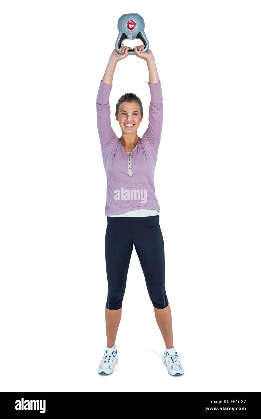 Portrait of happy young woman exercising with kettlebell Stock Photo ...