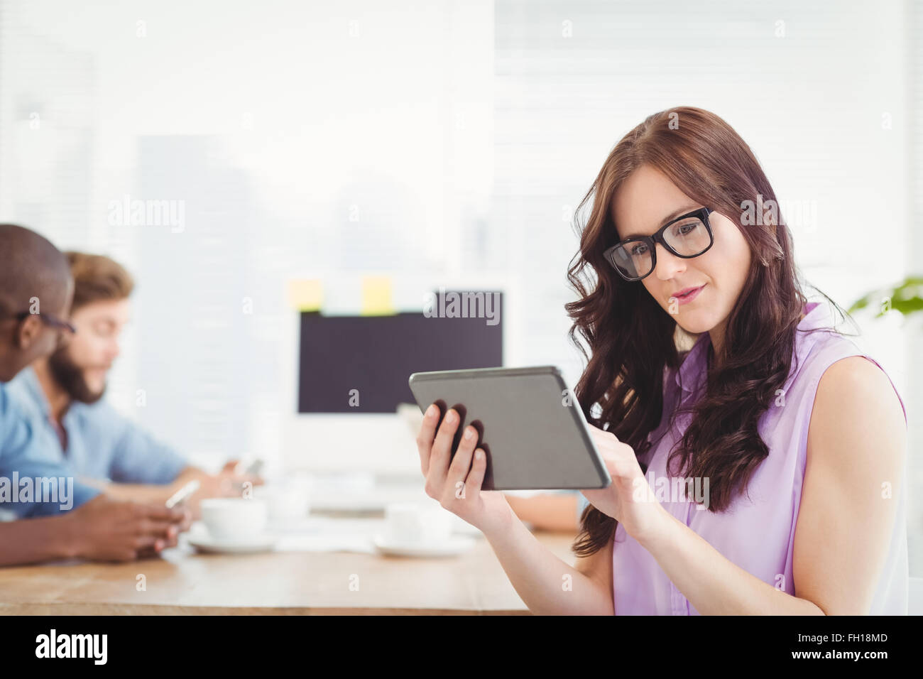 Thoughtful woman holding digital tablet at desk Stock Photo - Alamy