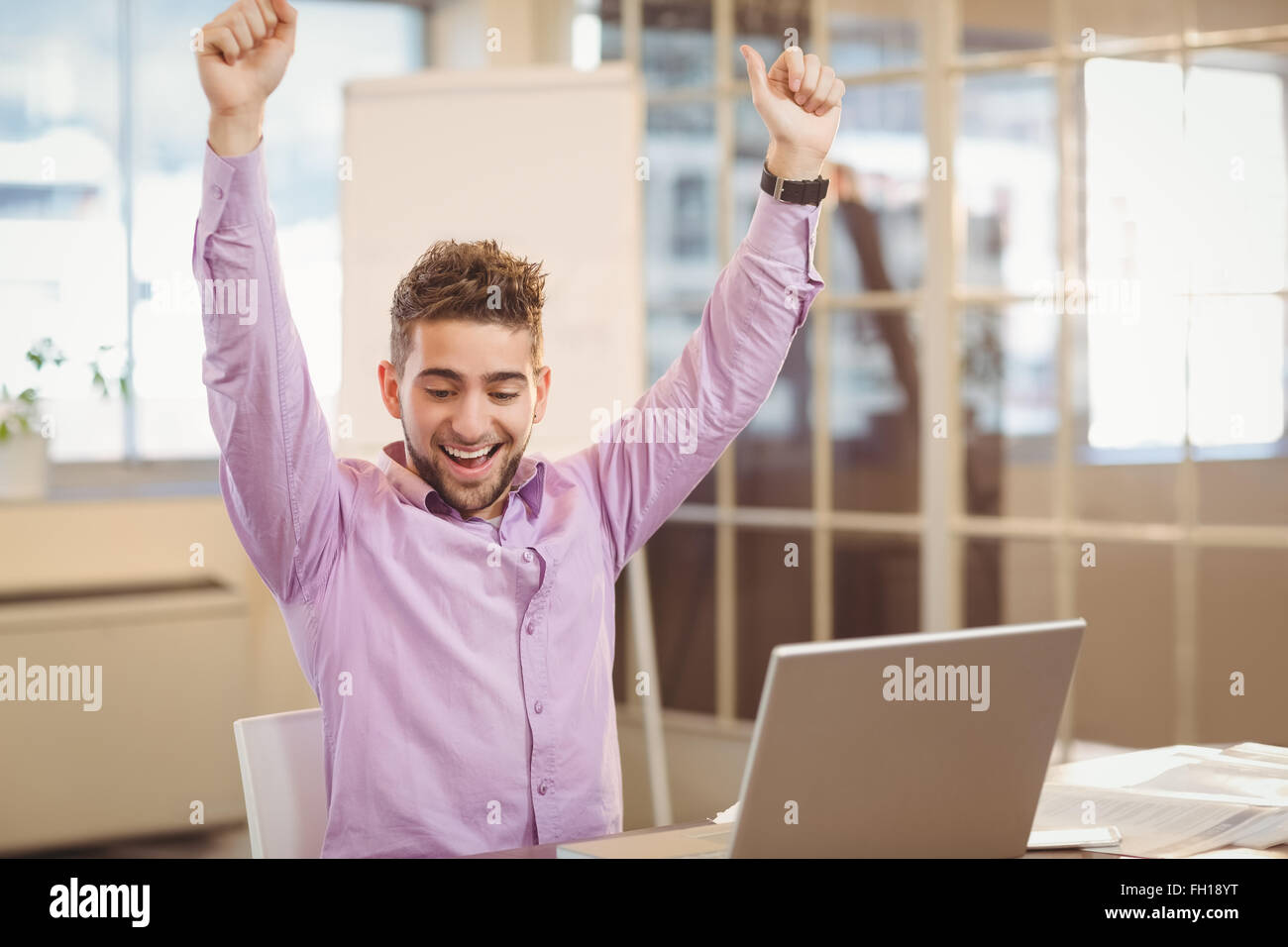 Happy businessman with arms raised Stock Photo - Alamy