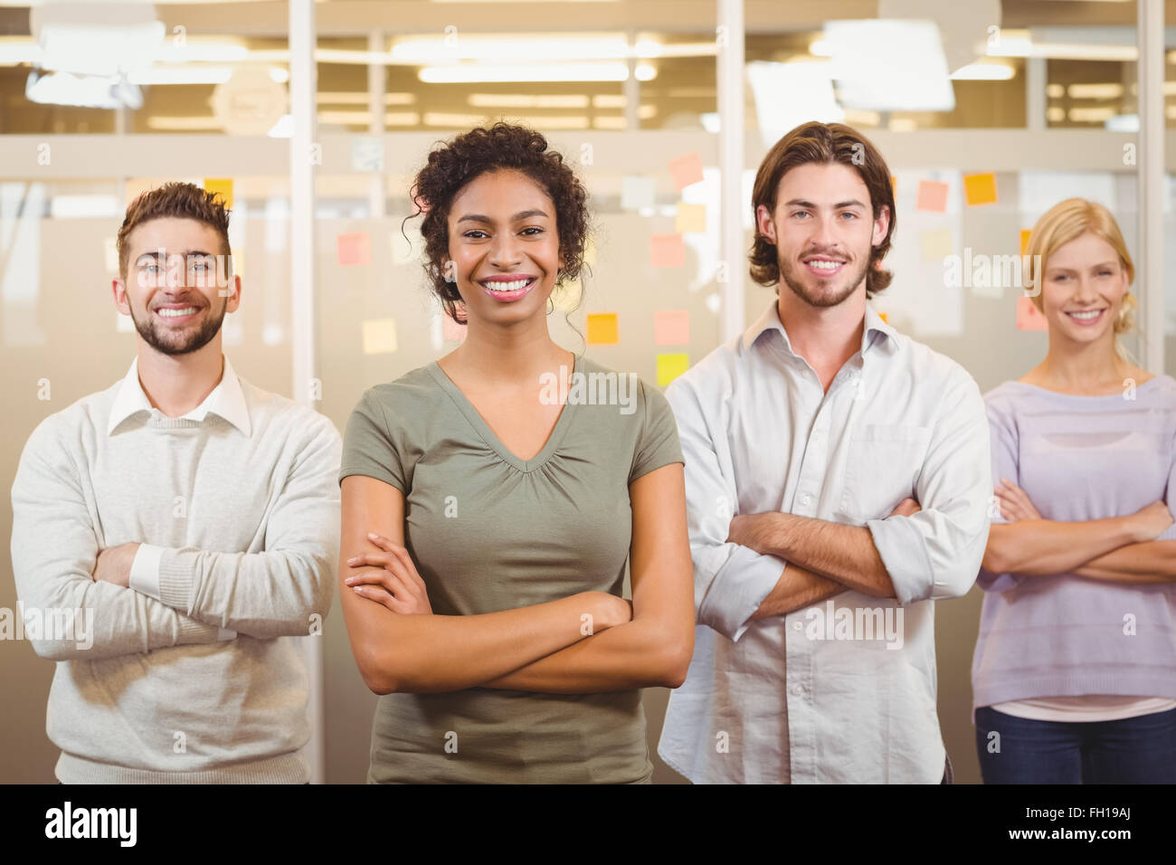 Portrait of smiling business team with arms crossed in office Stock ...