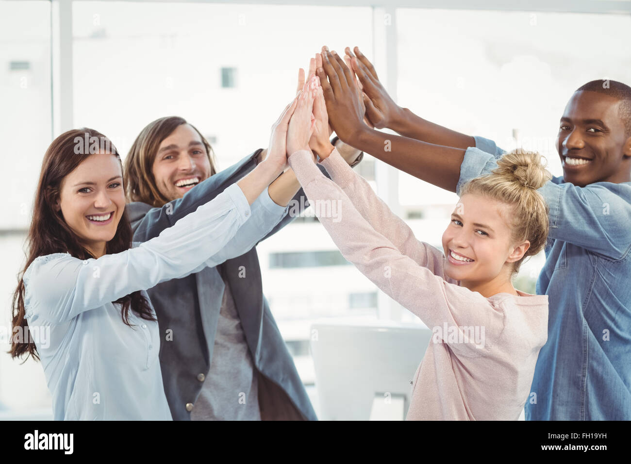 Portrait of smiling business team giving high five Stock Photo - Alamy