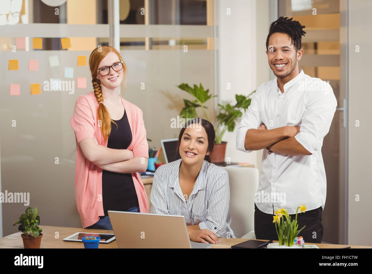 Portrait of happy business people with arms crossed in office Stock ...