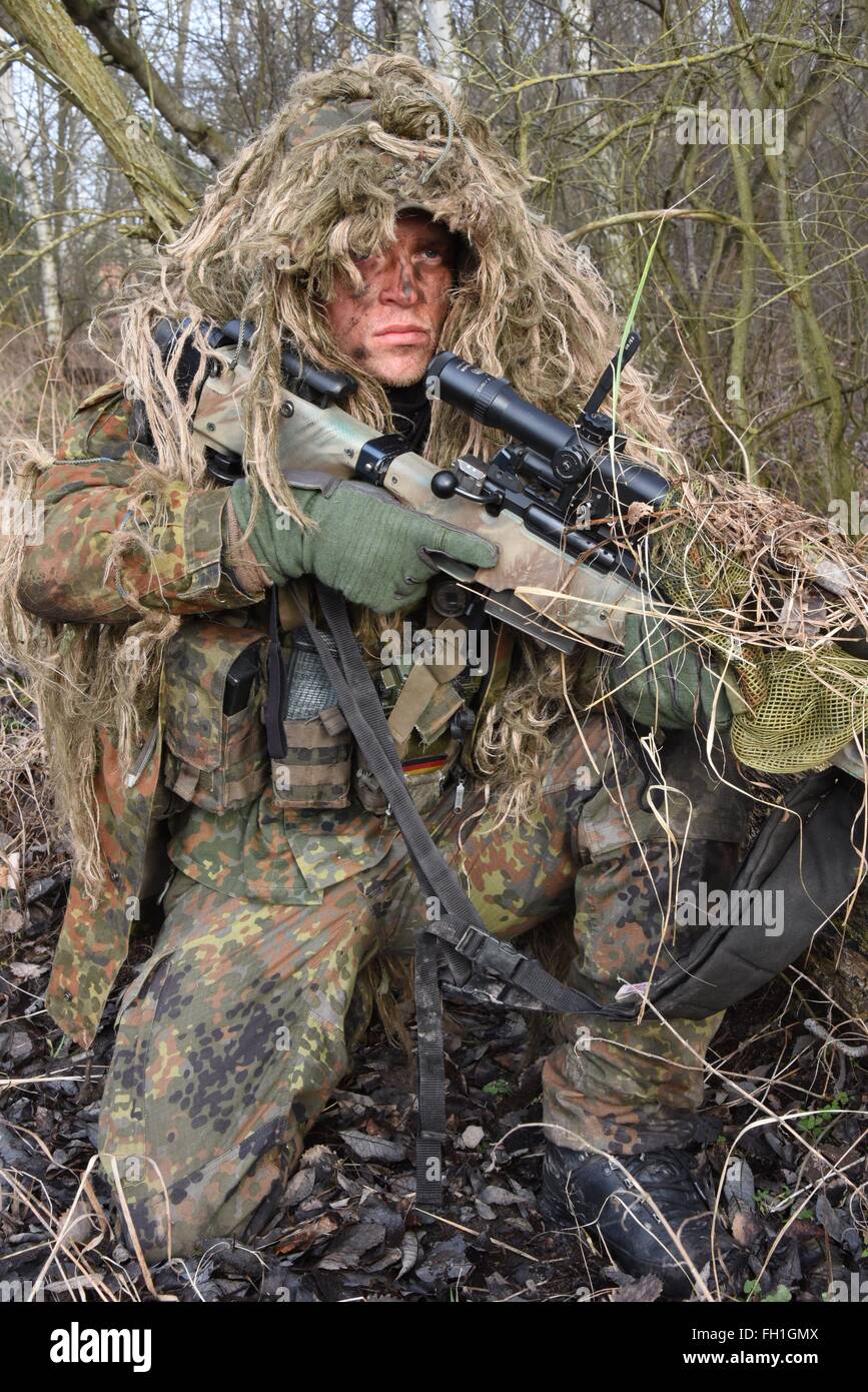 Camouflaged woman sniper in ghillie suit posing with rifle in foggy night.  Special Weapons and Woman Concept Stock Photo - Alamy