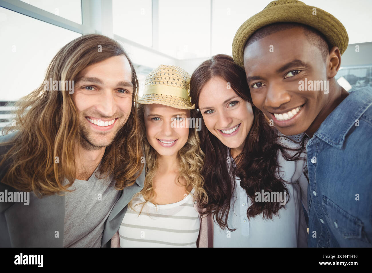 Portrait of smiling business team with arms around at office Stock ...