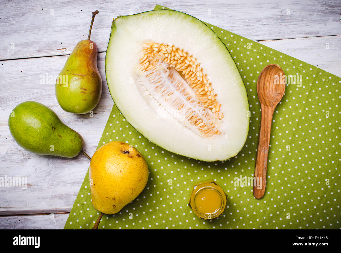 Melon with honey and green yellow pears on wood in rustic style Stock Photo