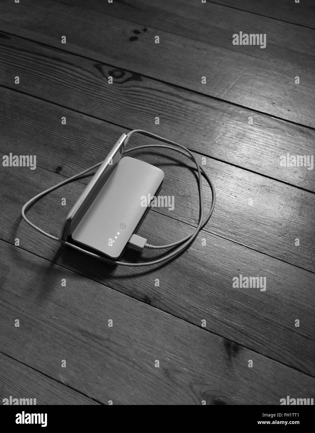 Battery and cellphone on the wooden background Stock Photo