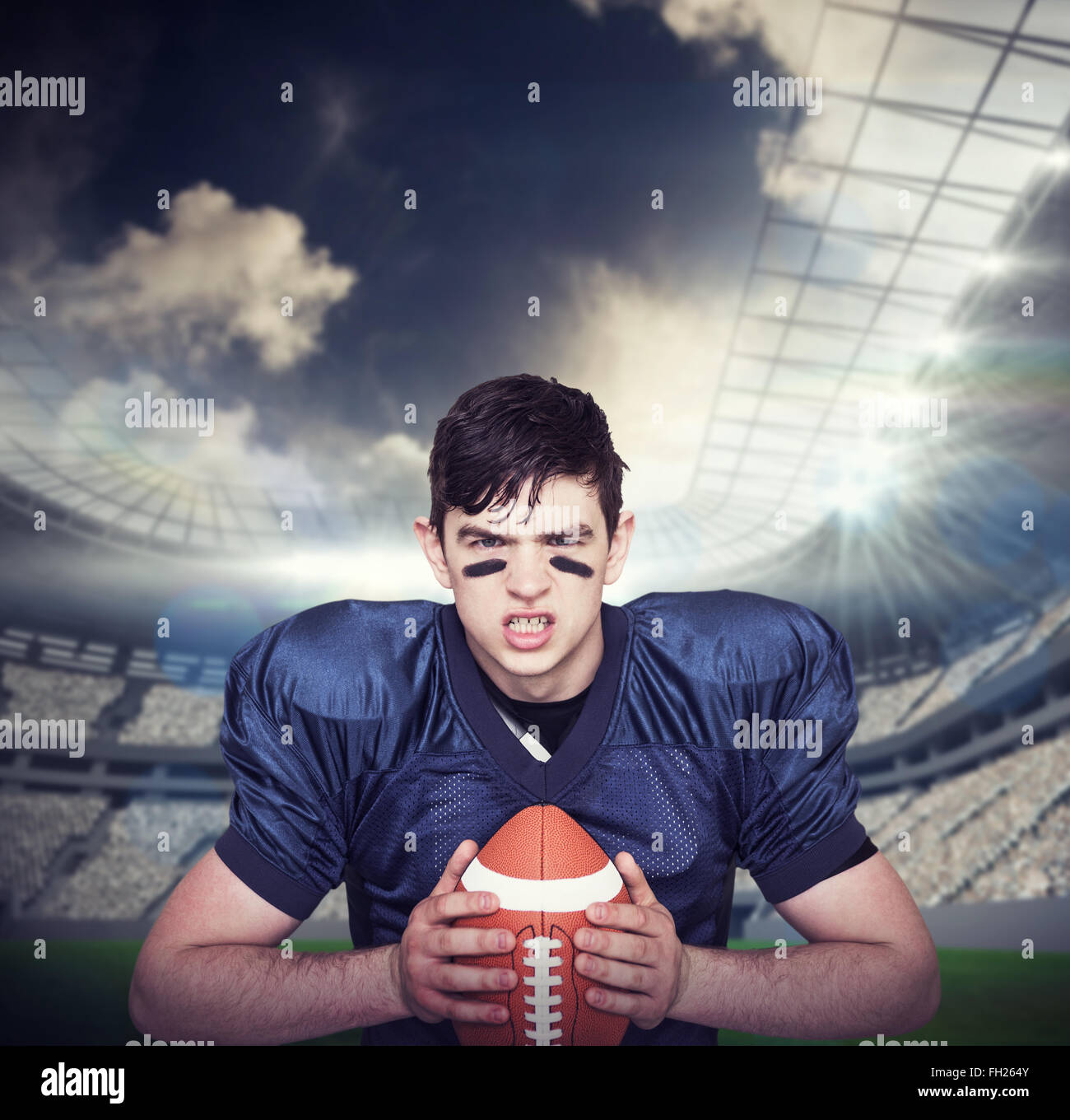 Composite image of enraged american football player holding a ball Stock Photo