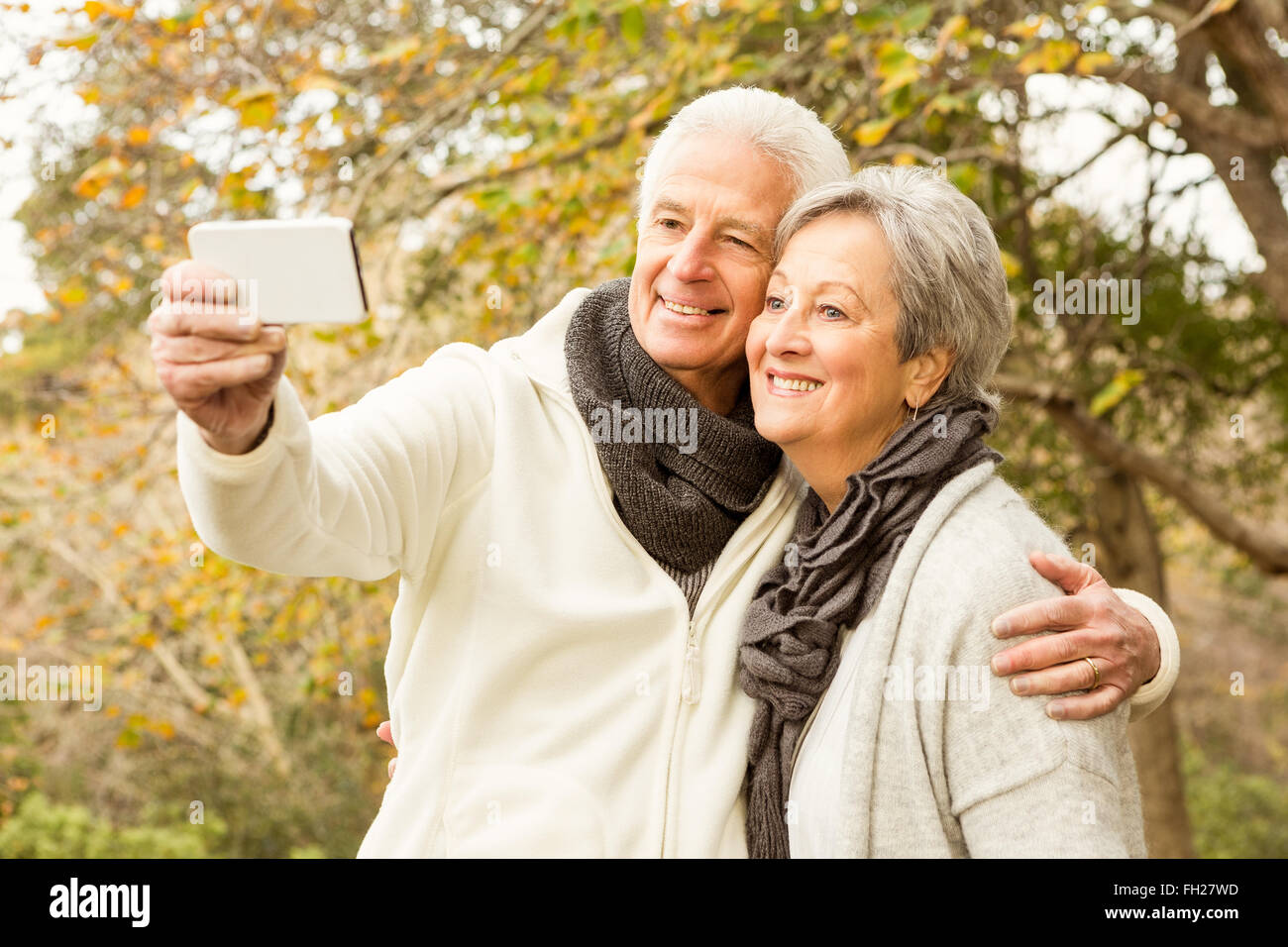 Senior couple in the park taking selfie Stock Photo - Alamy